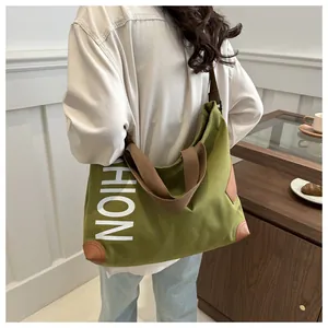 Detail of green canvas tote bag with brown leather patches and HION letter printing