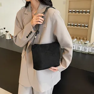 Sac seau minimaliste en daim noir avec longues bandoulières en cuir et nœuds