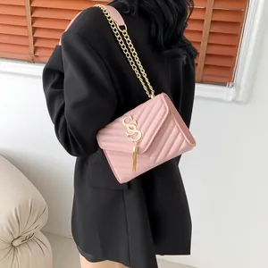 Pink V-quilted faux leather crossbody bag with gold chain strap and tassel detail