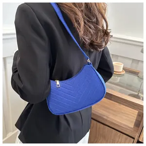 Detail of Klein blue wool crescent shoulder bag with elegant V-shaped quilted stitching