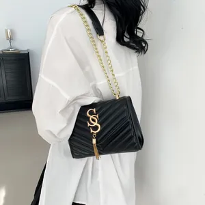 Chic black quilted leather crossbody bag with gold chain strap and stylish tassel detail