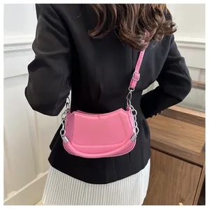 Détail du sac demi-lune rose avec chaîne argentée et inscription FASHION & BAGS