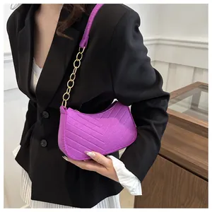Detailed view of purple hobo bag with V-shaped quilting and golden chain strap