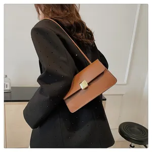 Gros plan sur le sac porté épaule en cuir marron caramel avec boucle carrée en métal doré