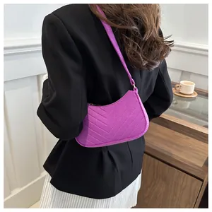 Detail of purple chevron quilted crossbody bag shown on model for size and style