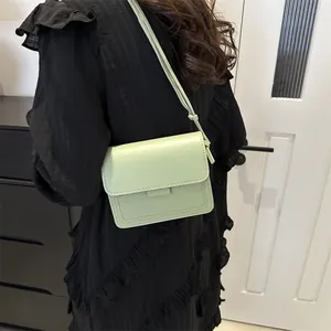 Borsa a tracolla minimalista verde menta in pelle con patta e cinturino da donna