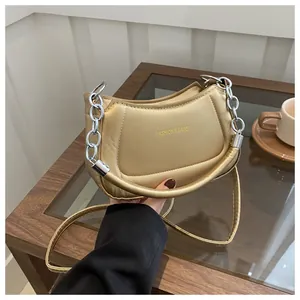 Détail du sac croissant doré champagne avec fini matelassé et chaîne argentée