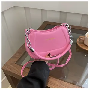 Détail du sac demi-lune rose avec poignée épaisse et détails de chaîne en argent