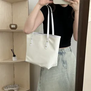 Minimalist white PU leather tote bag with gold rivets shown in a casual home mirror selfie