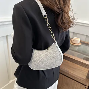 Chic gray felt crescent shoulder bag with quilted texture and gold chain strap detail