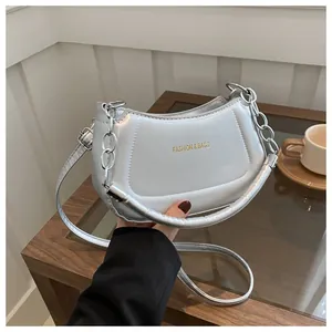 Gros plan du sac croissant argenté avec lettrage FASHION & BAGS et détail de chaîne
