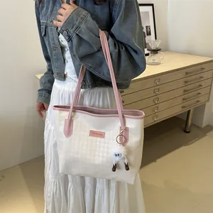 White canvas tote bag with pink trim and cute plush monster charm for women