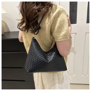 Detail of the black woven texture and slender strap of the hobo shoulder bag for women