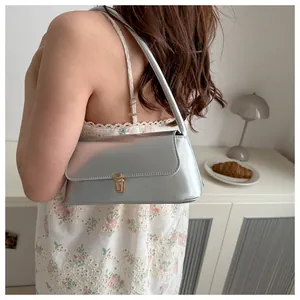 Detailansicht einer silbernen Spiegel-Baguette-Tasche mit goldener Metallschnalle