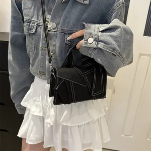 Mini sac carré minimaliste en denim noir avec coutures blanches et bandoulière réglable