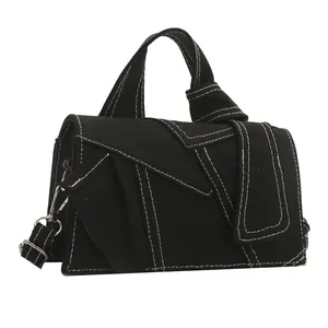 Sac bandoulière en denim noir avec coutures blanches contrastées et détails argentés
