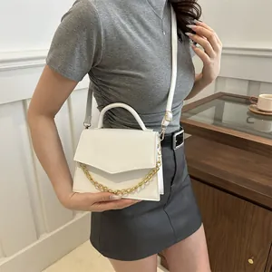 White faux leather crossbody bag with gold chain and crocodile texture on a model