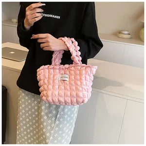 Detail of pink plissé shoulder bag with Love Fashion tag and textured fabric finish