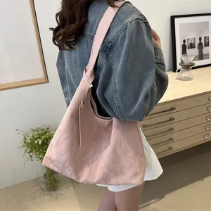 Sac fourre-tout rose minimaliste à texture, porté par un mannequin avec bandoulière