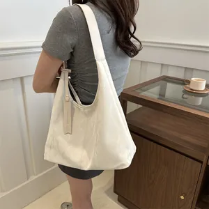 Grand sac fourre-tout beige au design plissé avec étiquette de mode porté à l'épaule