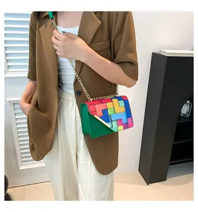 Détail du petit sac bandoulière géométrique multicolore avec chaîne dorée sur mannequin