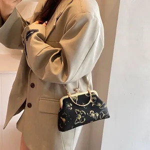 Bolso de mano vintage negro minimalista con bordado de mariposa y asa dorada