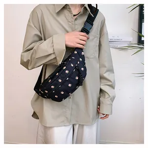 Detail of adjustable strap and floral pattern on the dark crossbody waist bag