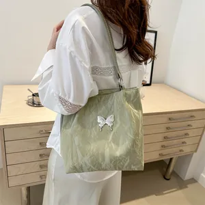 Sac fourre-tout vert clair à texture froissée avec accent en métal de papillon blanc