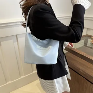 Minimalist light blue bucket bag with onwards and upwards embroidery on shoulder strap