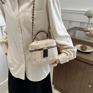 Minimalist straw crossbody bucket bag with floral embroidery and gold chain strap