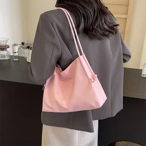 Minimalist soft pink leather tote bag for women shown as a stylish shoulder bag in a cafe