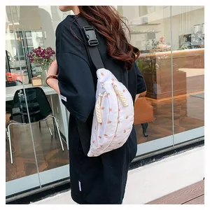 Close-up of floral print waist bag with black nylon strap on model at a cafe