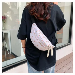 Detail of floral canvas waist bag showing pink flower pattern and woven rope pullers