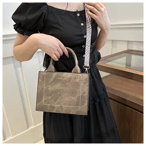 Detail van de donkerbruine retro crossbodytas met een brede geometrische schouderband