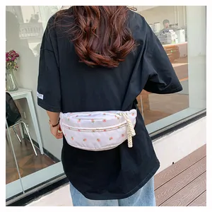 Close-up of floral fanny pack with pink rose pattern on white canvas for daily casual use