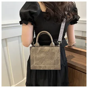 Achteraanzicht van model met bruine crossbodytas en brede geometrische schouderband