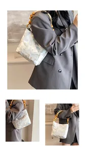 Detail der eleganten Schmetterlingsstickerei und Holzperlengriff an Vintage-Umhängetasche