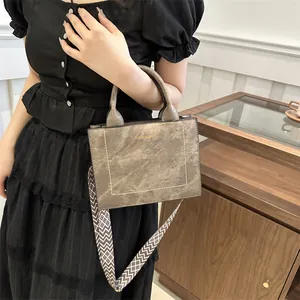Koffiebruine crossbody tas met brede schouderriem met patroon in een huiselijke sfeer