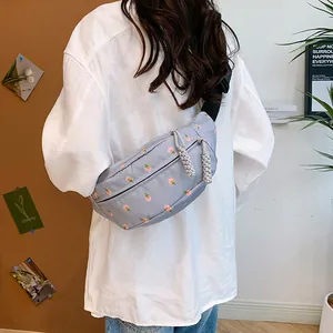 Blue floral waist bag for women with dual zippers and adjustable strap shown on model