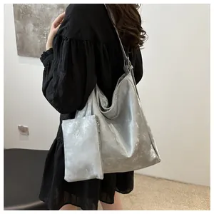 Dettaglio borsa tote argento metallizzato con astuccio coordinato e trama moderna