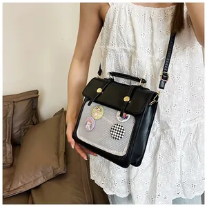 Detailansicht der schwarzen Ita-Tasche mit transparentem Gitter und süßen Cartoon-Badges