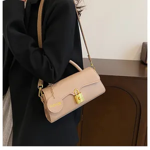 Detail of apricot matte leather crossbody bag featuring gold clasp and fashion tag