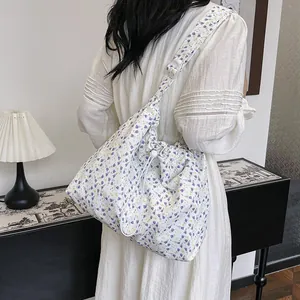 Floral drawstring bucket bag with purple and yellow flower patterns on white fabric