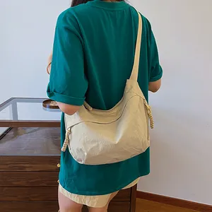 Sac bandoulière léger en nylon crème avec tirette tressée pour un usage quotidien