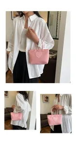 Detailed view of pink nylon tote bag featuring a stitched heart patch with a smile design