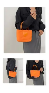 Multi-angle view of bright orange mini tote bag with heart smiley patch detail