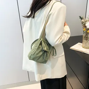 Minimalist light green nylon drawstring bucket bag with adjustable shoulder strap for women
