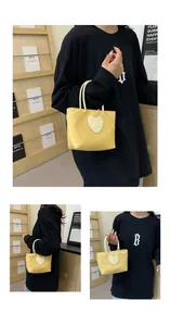 Detail of yellow nylon tote bag featuring a heart-shaped smiley face patch and rope handles