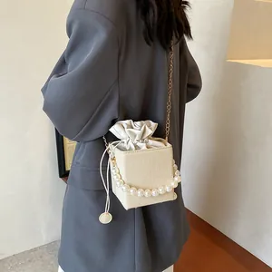 Sac seau tissé beige chic avec poignée en perles élégante et bandoulière chaîne dorée