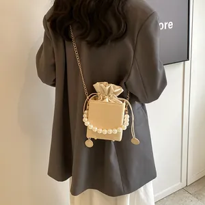 Sac seau tissé élégant avec poignée en perles et chaîne dorée au style boîte beige